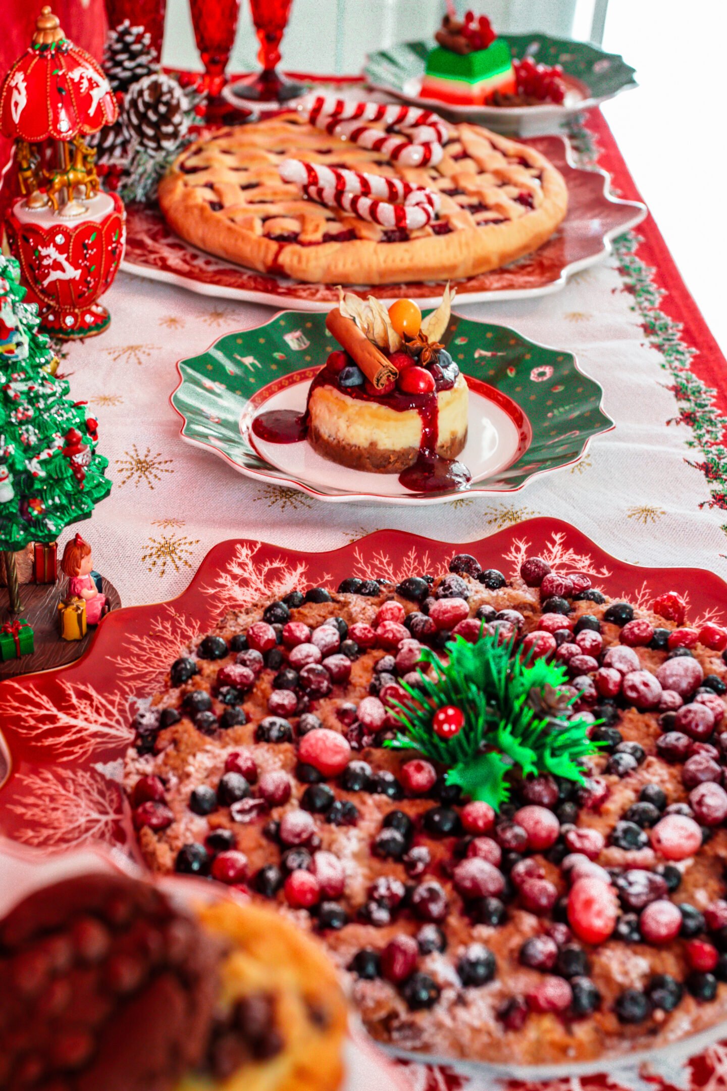  Christmas table deserts  with berry pie, cheesecake, and Christmas decorations.